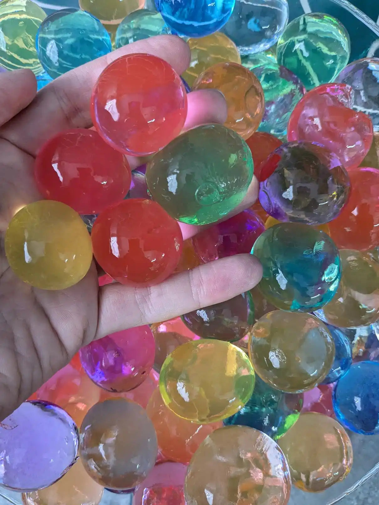 Colorful water beads in hand.